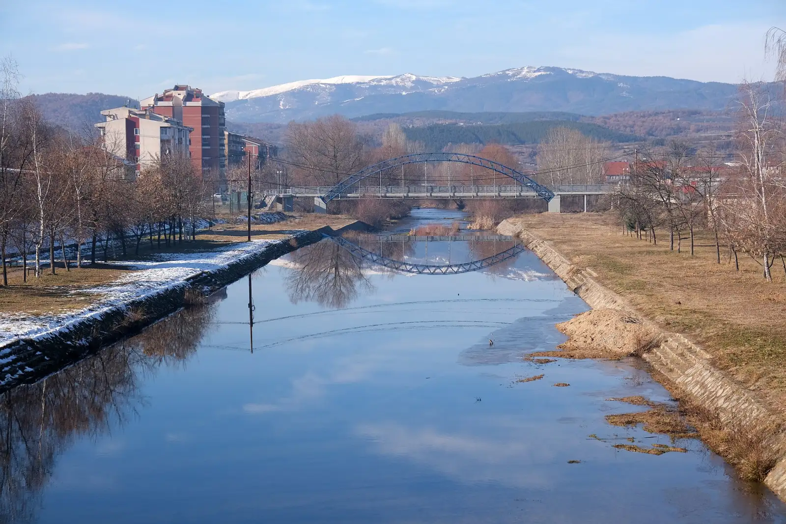 Мостот над реката Брегалница во Делчево, со снежните врвови на Осогово во позадина