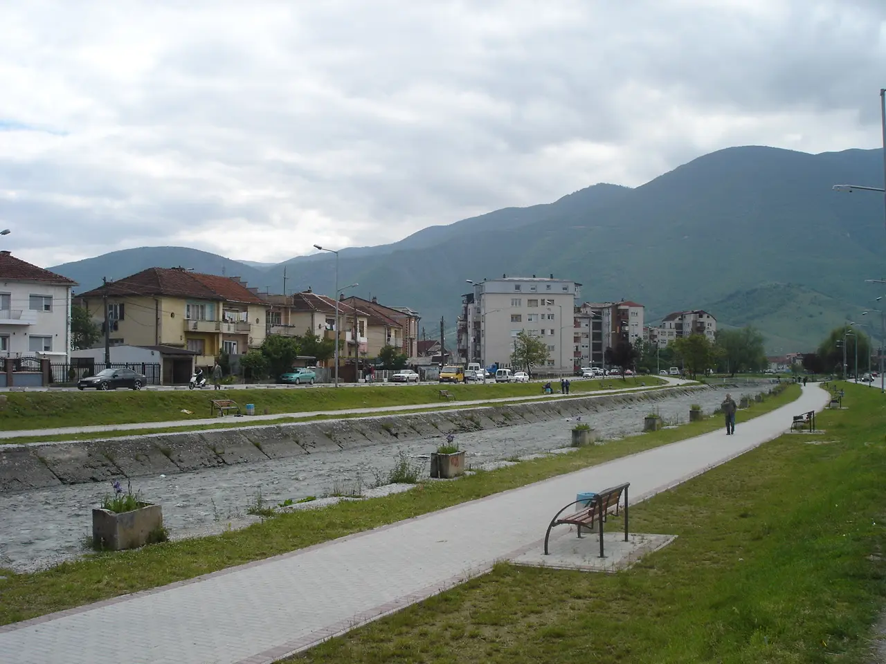 Кејот покрај реката Вардар во Гостивар, со уредена патека и ридовите во позадина